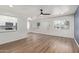 Spacious living room with laminate flooring, a ceiling fan, and a view into the kitchen at 1702 W Tuckey Ln # 123, Phoenix, AZ 85015