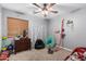 Playful bedroom with a ceiling fan, a window with blinds, and decor for a play area at 17347 W Statler St, Surprise, AZ 85388