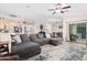 Spacious living room featuring a plush gray sectional, open layout to kitchen, and plenty of natural light at 17347 W Statler St, Surprise, AZ 85388