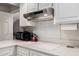 White kitchen with cooktop, overhead ventilation, and white cabinets at 19127 E Wiki Way, Rio Verde, AZ 85263