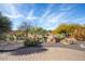 Landscaped backyard with desert plants and brick patio at 20642 N 268Th Dr, Buckeye, AZ 85396