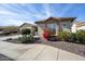 Charming home exterior with stone accents and red flowering bush at 20642 N 268Th Dr, Buckeye, AZ 85396