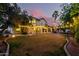 Expansive backyard featuring a covered patio, string lights, and a lush lawn creating an inviting outdoor space at 211 E Dawn Dr, Tempe, AZ 85284