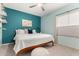 Stylish bedroom with a white bed, turquoise accent wall, and a ceiling fan at 211 E Dawn Dr, Tempe, AZ 85284