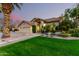 Well-manicured front yard featuring lush green lawn, desert landscaping, mature trees, and a charming two-story home at 211 E Dawn Dr, Tempe, AZ 85284