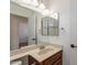 Bathroom featuring a vanity with granite countertop, large mirror, and wood cabinetry at 235 N 22Nd Pl # 565, Mesa, AZ 85213