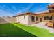 Backyard showing artificial turf, patio with dining table and desert landscaping around house at 2637 S Sandstone St, Gilbert, AZ 85295