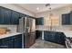 Well-lit kitchen with modern appliances, dark cabinets, a stainless-steel refrigerator, and tile floors at 2637 S Sandstone St, Gilbert, AZ 85295