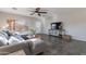 Bright living room with a ceiling fan, large windows, tile flooring, and a comfortable sectional sofa at 2637 S Sandstone St, Gilbert, AZ 85295