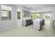 Modern kitchen with island and gray cabinets, opens to dining area at 28107 N 123Rd Ln, Peoria, AZ 85383