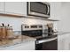 Modern kitchen showcasing stainless steel range and microwave, granite countertops, and ample cabinet space at 28242 N Nealite Dr, San Tan Valley, AZ 85143