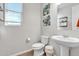 Simple bathroom with pedestal sink, toilet, and decorative art at 2885 W New River Dr, San Tan Valley, AZ 85144