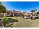 Inviting backyard featuring a covered patio, outdoor kitchen, pool, and ample green space at 3036 E Boston St, Gilbert, AZ 85295