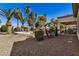 Gravel-covered backyard featuring a refreshing pool and spa with privacy landscaping and palm trees at 3036 E Boston St, Gilbert, AZ 85295