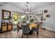 Bright dining area with modern chandelier, round wooden table, and sliding door access to the patio at 3036 E Boston St, Gilbert, AZ 85295