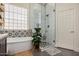 This main bathroom features a stand-alone tub next to a glass-enclosed shower with designer tile at 3036 E Boston St, Gilbert, AZ 85295