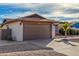 Two-car garage with brown door and gravel driveway at 3125 W Waltann Ln, Phoenix, AZ 85053