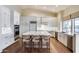 Bright kitchen featuring an island with seating, white cabinets, and hardwood floors at 5635 W Melinda Ln, Glendale, AZ 85308