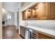 Wet bar with wood cabinets, quartz countertops, and a wine cooler at 5635 W Melinda Ln, Glendale, AZ 85308