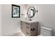 Bathroom vanity features black hardware, countertop, round mirror with attached lights, and a window at 6331 E Earll Dr, Scottsdale, AZ 85251