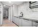 Well organized laundry room features white cabinets, dark hardware, floating shelves, and tile backsplash at 6331 E Earll Dr, Scottsdale, AZ 85251