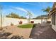 Landscaped backyard featuring a turf lawn, desert plants, and a stucco wall at 7390 E Hanover Way, Scottsdale, AZ 85255