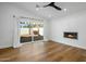 Bright living room featuring wood floors, a fireplace, and sliding glass doors to the backyard at 7390 E Hanover Way, Scottsdale, AZ 85255