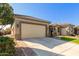 Tan house with a two-car garage and a manicured lawn at 7815 W Cinder Brook Way, Florence, AZ 85132