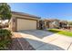 Tan house with a two-car garage and a manicured lawn at 7815 W Cinder Brook Way, Florence, AZ 85132