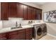 Laundry room with washer, dryer, and dark wood cabinets at 7815 W Cinder Brook Way, Florence, AZ 85132