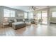 Spacious living room with wood-look tile flooring, a ceiling fan, and abundant natural light at 8535 E Olla Ave, Mesa, AZ 85212