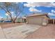 House exterior showcasing a tan garage door and gravel yard at 8732 W Granada Rd, Phoenix, AZ 85037