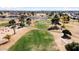 Aerial view of a golf course with pond and distant city views at 10377 W White Mountain Rd, Sun City, AZ 85351