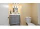 Guest bathroom with toilet and gray vanity at 10377 W White Mountain Rd, Sun City, AZ 85351