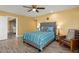 Bedroom with gray upholstered bed and wood floors at 10377 W White Mountain Rd, Sun City, AZ 85351