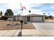 Single-story home exterior with landscaped yard and American flag at 10377 W White Mountain Rd, Sun City, AZ 85351