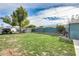 Spacious backyard with a vibrant lawn, a shed, and a parked off-road vehicle at 10433 E Boise St, Apache Junction, AZ 85120