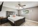 Bedroom with a large bed, dark wood furniture, ceiling fan, and window providing natural light at 10433 E Boise St, Apache Junction, AZ 85120