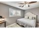 Cozy bedroom featuring a queen bed, soft lighting from a ceiling fan, and window at 10433 E Boise St, Apache Junction, AZ 85120