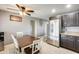 Bright kitchen with tile flooring, stainless steel refrigerator, and a dining area with a modern ceiling fan at 10433 E Boise St, Apache Junction, AZ 85120