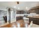 Open kitchen with stainless steel appliances, dark cabinetry, and dining space with natural light at 10433 E Boise St, Apache Junction, AZ 85120