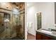 Bathroom featuring walk-in shower with decorative tile work and a dark vanity at 10712 E Prospect Point Dr, Scottsdale, AZ 85262