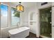 Bright bathroom featuring a soaking tub, shower and decorative lighting fixture at 10712 E Prospect Point Dr, Scottsdale, AZ 85262