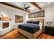 Bedroom featuring wooden ceiling beams, a decorative fireplace, and windows with wooden shutters at 10712 E Prospect Point Dr, Scottsdale, AZ 85262