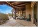 Inviting covered patio with stone flooring, rustic wood beams, and comfortable seating area at 10712 E Prospect Point Dr, Scottsdale, AZ 85262