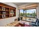 Bright den with built-in shelving, a comfortable couch, and sliding glass doors to patio at 10712 E Prospect Point Dr, Scottsdale, AZ 85262