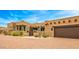 Wide angle view of a Southwestern style home focusing on its garage doors and desert landscaping at 10712 E Prospect Point Dr, Scottsdale, AZ 85262