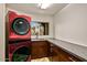 Well-equipped laundry room with modern red washer and dryer and ample counter space at 10712 E Prospect Point Dr, Scottsdale, AZ 85262