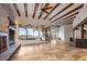 Spacious living room with exposed beams, stone fireplace, travertine floors, and picturesque views at 10712 E Prospect Point Dr, Scottsdale, AZ 85262