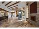 Open-concept living room with stone fireplace, exposed wood beams, travertine flooring, and arched doorways at 10712 E Prospect Point Dr, Scottsdale, AZ 85262